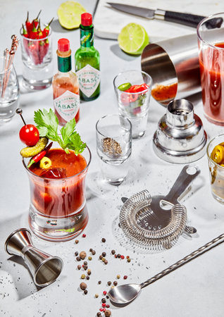 LONDON, UK - MARCH 22, 2023: Tabasco sauce with bloody mary pepper mix with cocktail utensils on light board.のeditorial素材