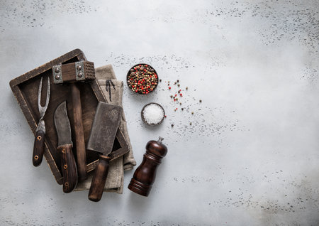Box of various vintage meat preparation utensils with pepper grinder and salt.Top view.の写真素材