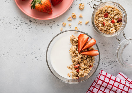 Strawberry organic granola with milk and fresh berries on light kitchen board. Top view.の写真素材