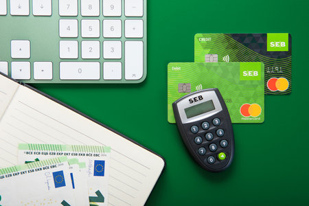 LONDON,UK - NOVEMBER 15, 2022: Seb bank credit and debit mastercard on green with code calculator and euro banknotes.Top viewのeditorial素材