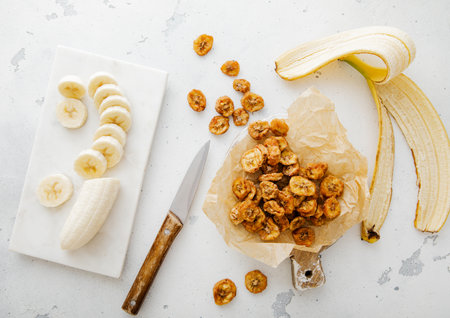 Peeled banana with dried healthy chips snack on light board.Top view.の写真素材