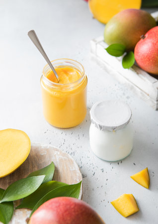 Greek style yogurt with mango puree and fruits on light background.Top view.の写真素材