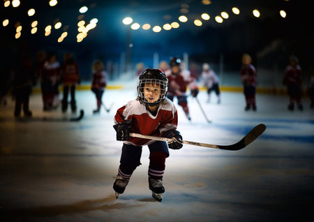 Little boy ice hockey player with hockey stick on large arena during training.AI Generative.の素材