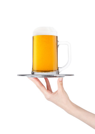 Hand holds tray with lager beer glass with foam and dew isolated on white backgroundの写真素材
