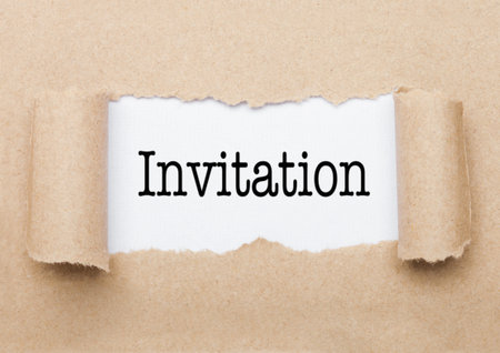 Invitation text appearing behind torn brown paper envelopeの写真素材