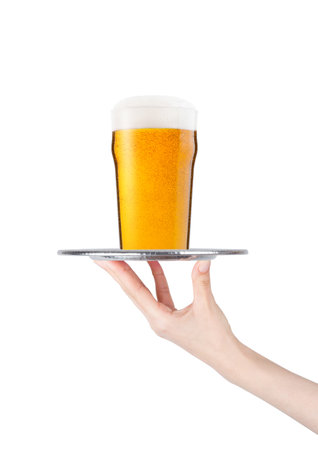 Hand  holds tray with lager beer glass with foam and dew isolated on white backgroundの写真素材