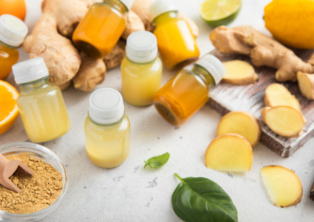 Ginger and turmeric energy shot immune drink with ginger root and turmeric powder on light background.の写真素材