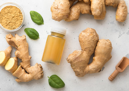 Immune ginger energy shot drink with fresh raw ginger root on light background.の写真素材