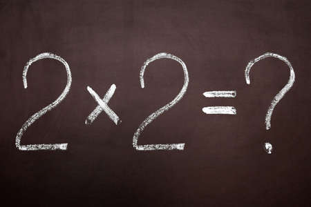 On a blackboard the chalk writes a simple sumの写真素材