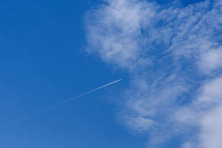 White fluffy clouds highly float in the blue skyの写真素材