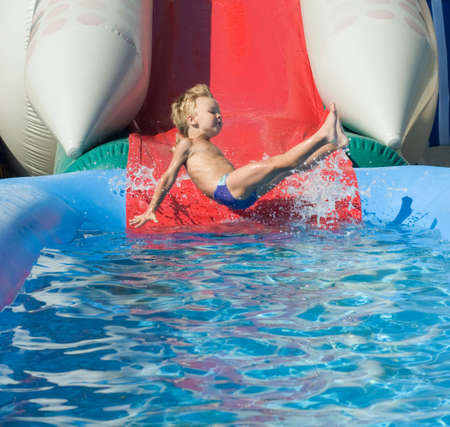 Young boy on water slide at a vacation resortの写真素材