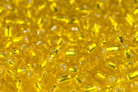 Macro shot of small golden glass beads - backgroundの写真素材