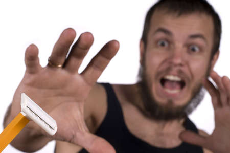 Young man with beard looking on razor - criedの写真素材