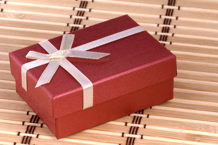 One red gift box with white ribbon and bow and isolatedの写真素材