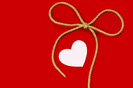 Red blank note and golden ribbon isolated on white background for Valentine's Dayの写真素材