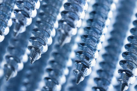 Close-up of silver screws as technology background