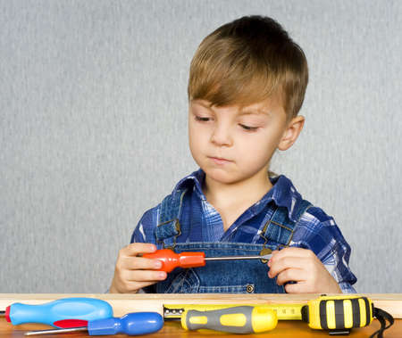 Cute kid as a construction worker, playing with toolsの写真素材
