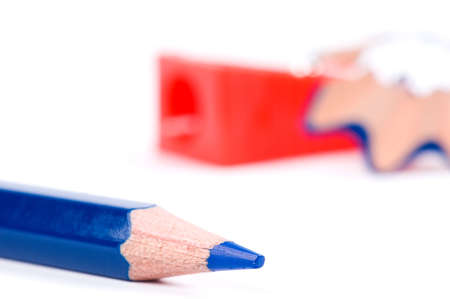 Blue pencil, red sharpener and wood shavings on white backgroundの写真素材