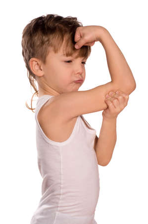 Portrait of little european boy flexing biceps. Beautiful caucasian model. Isolated on white background.の写真素材