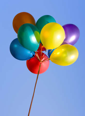 Bunch of colorful balloons in the blue skyの写真素材