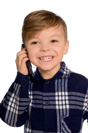 Funny little european boy speaks over cell phone. Beautiful caucasian model. Isolated on white background.の写真素材