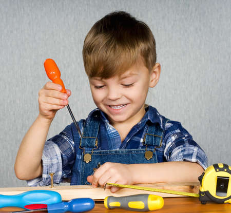 Cute boy as a construction worker, playing with toolsの写真素材