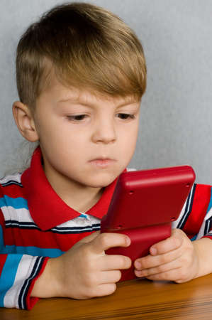 Little boy playing a tetris gameの写真素材