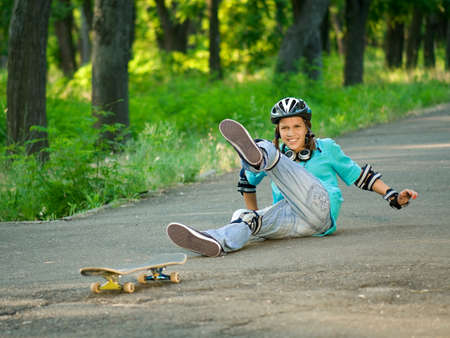 Beautiful teenage girl with skateboard in the green parkの写真素材