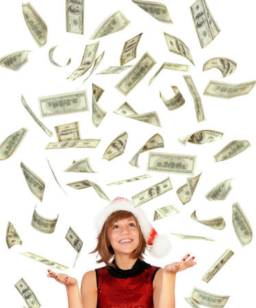 Smiling christmas girl catching falling dollars banknotes wearing Santa hat. Isolated on white background.の写真素材