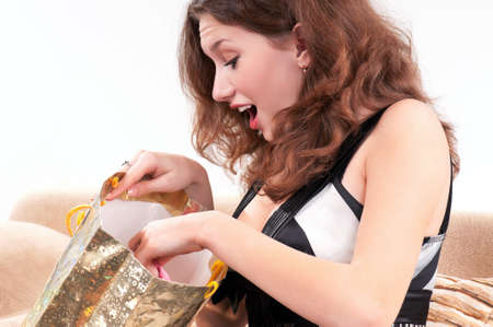 Beautiful young woman with shopping bag on divanの写真素材