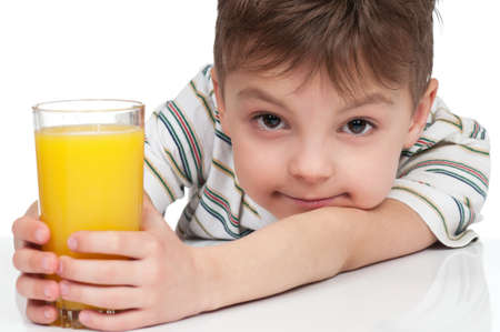 Little boy having a glass of refreshing oranges juice - isolated on whiteの写真素材
