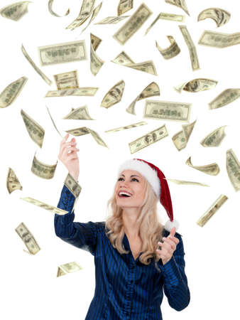 Smiling christmas girl catching falling dollars banknotes wearing Santa hat. Isolated on white background.の写真素材