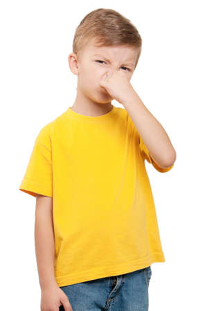 Portrait of little boy covering nose with hand on white backgroundの写真素材