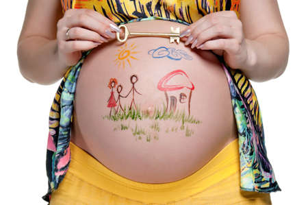 Tummy of pregnant woman with funny drawing over white backgroundの写真素材