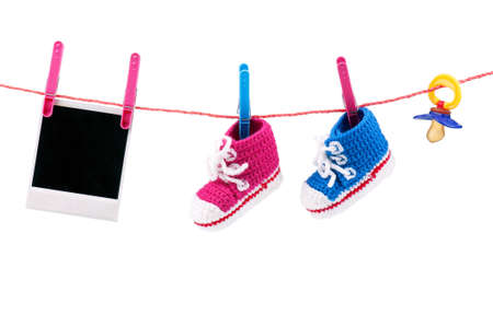 Baby bootees, photo and dummy on the clothesline on a white backgroundの写真素材