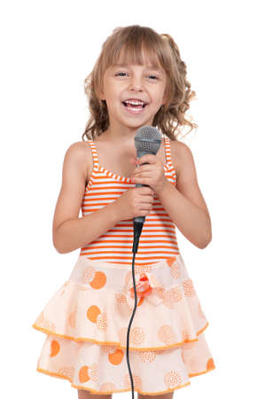 Funny little girl singing with a microphone isolated on white backgroundの写真素材