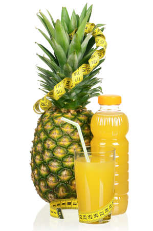 Fresh pineapple juice and ripe pineapple with a measure tape on white backgroundの写真素材