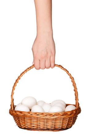 Basket with eggs in woman hand isolated on white backgroundの写真素材