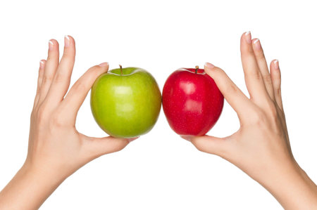 Woman hands with green and red apples isolated on white backgroundの写真素材