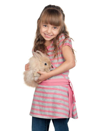 Easter concept image. Portrait of happy little girl with adorable rabbit over white background.の写真素材