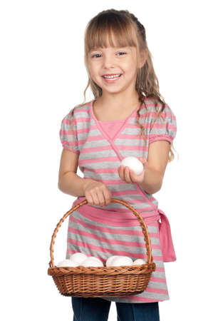 Happy little girl holding basket of eggs over white backgroundの写真素材