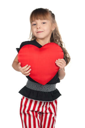 Portrait of little girl holding red heart over white backgroundの写真素材