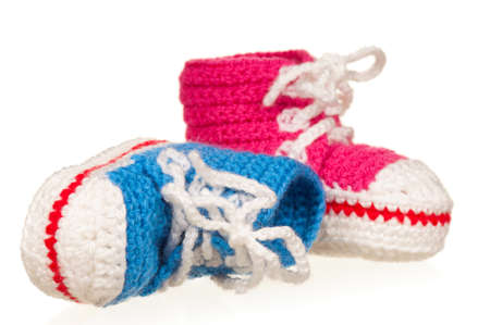 Handmade blue and pink baby booties isolated on white backgroundの写真素材
