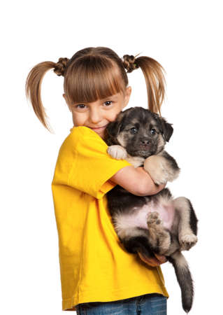Portrait of little girl with cute puppy isolated on white backgroundの写真素材