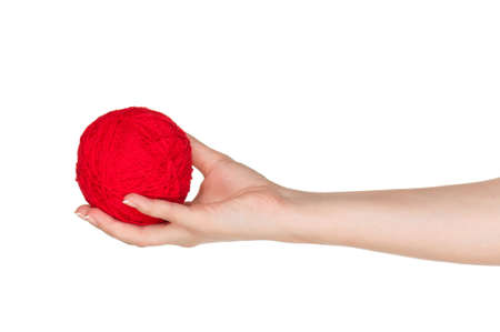 Woman hand with red ball of yarn for knitting isolated on white backgroundの写真素材