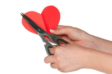 Woman hands with scissors and heart isolated on white background