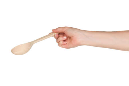 Woman hand with wooden spoon isolated on white backgroundの写真素材