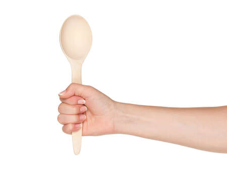 Woman hand with wooden spoon isolated on white backgroundの写真素材