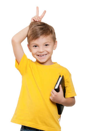 Portrait of little schoolboy holding book on white backgroundの写真素材