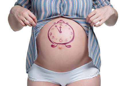 Tummy of pregnant woman with funny drawing over white backgroundの写真素材